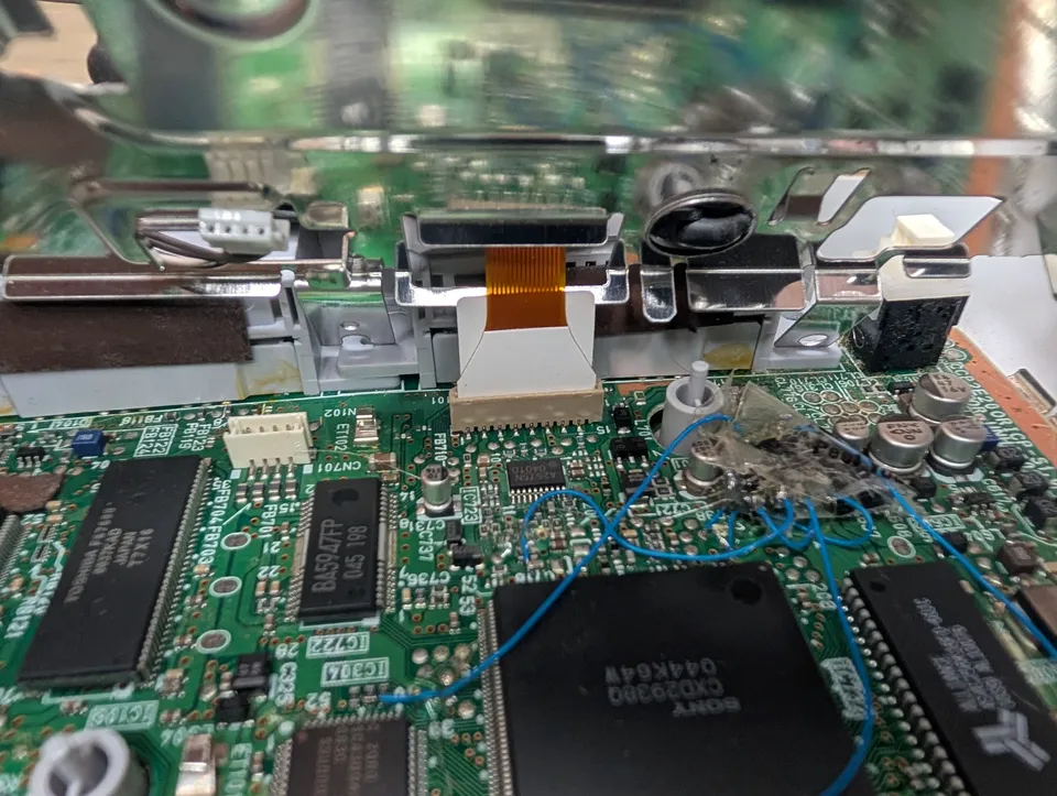The board under the drive, with a blob of hot glue and thin blue wires going everywhere.